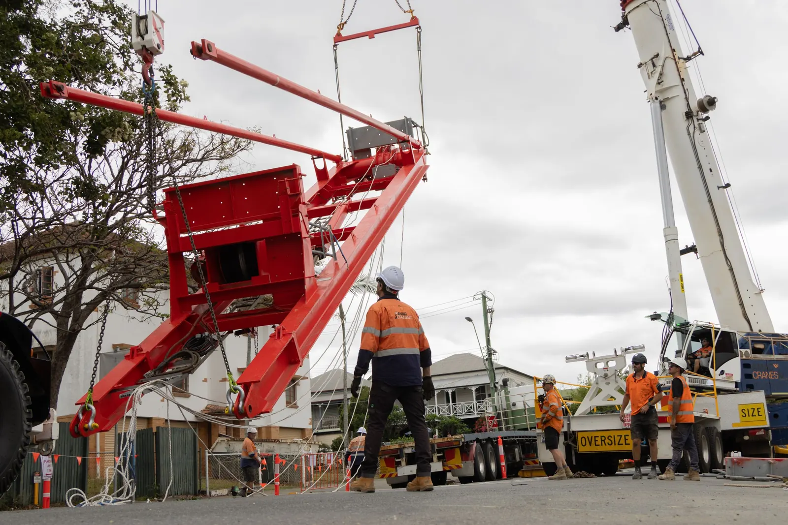 Tower crane section being lifted in a street