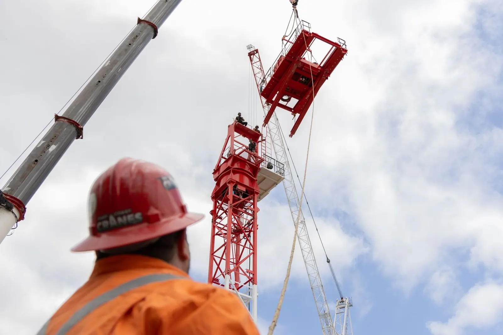 Crane crew working under a red jib