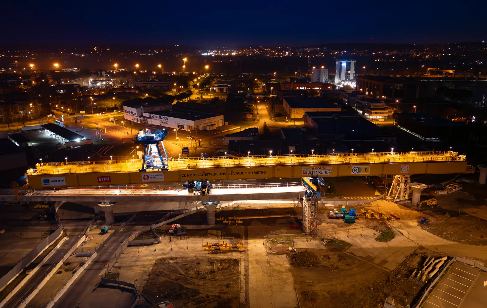 Construction site and city lights at night, from the air