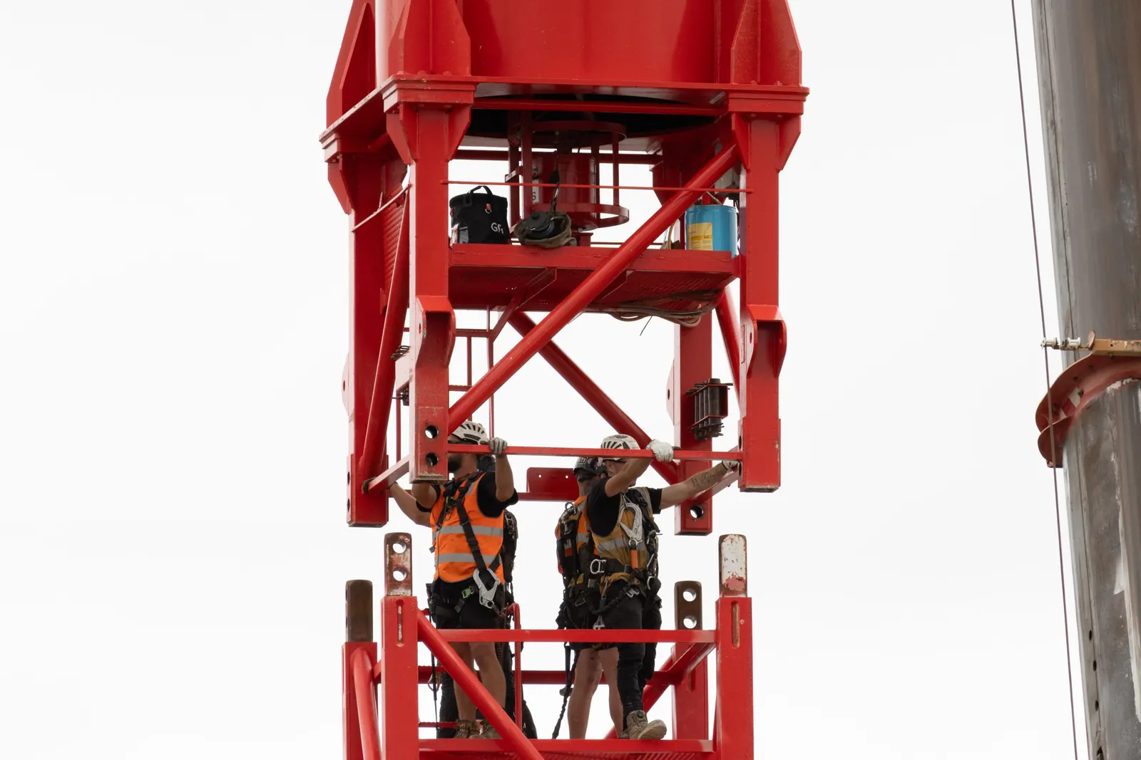Crew inside a red tower crane mast